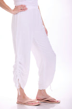 Side image of M Made in Italy pull on white ankle tie pants. 