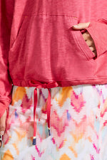 Front detail image of hot pink long sleeve top with kangaroo pocket. 